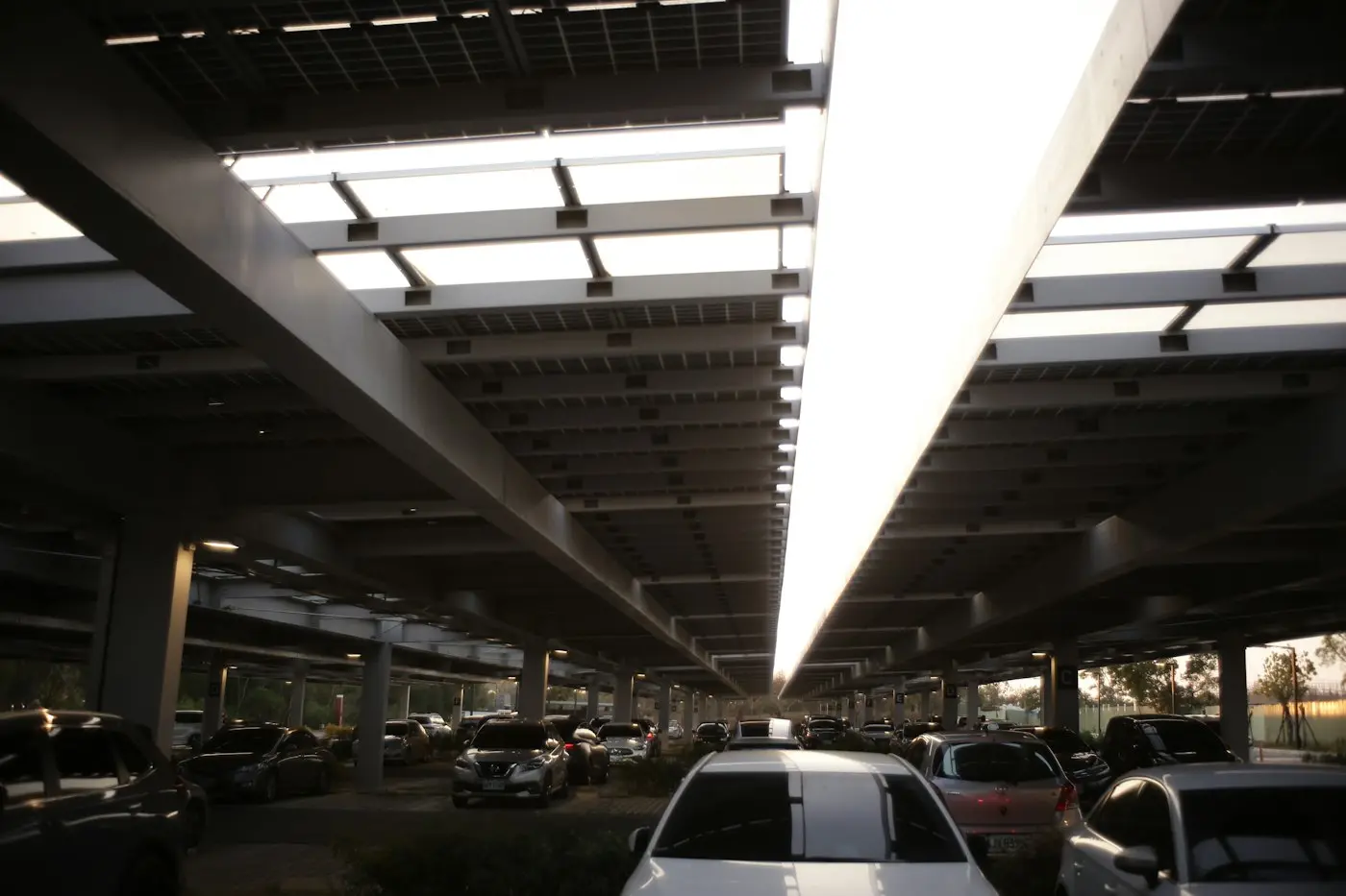 Autos estacionados bajo una cubierta de paneles solares