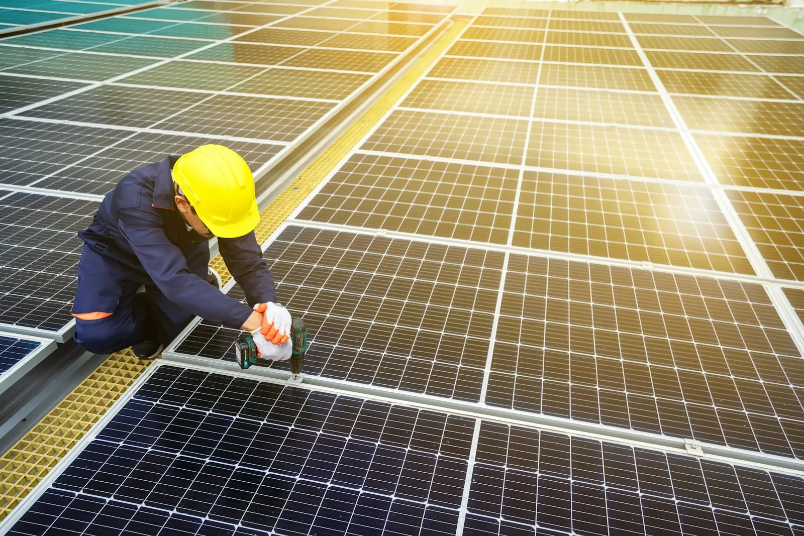Técnico con casco revisando paneles solares sobre una cubierta