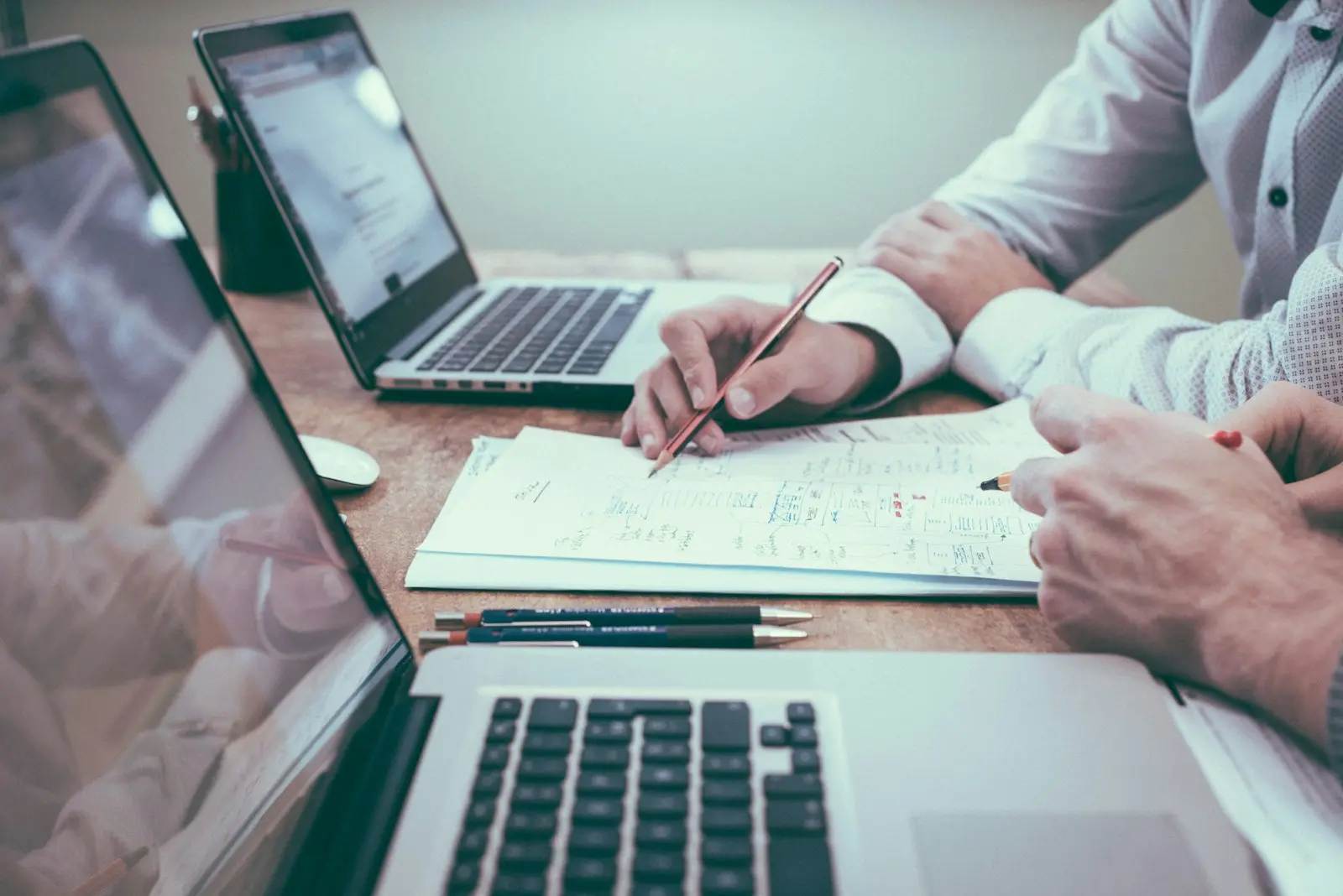 Dos personas revisando documentos junto a una computadora
