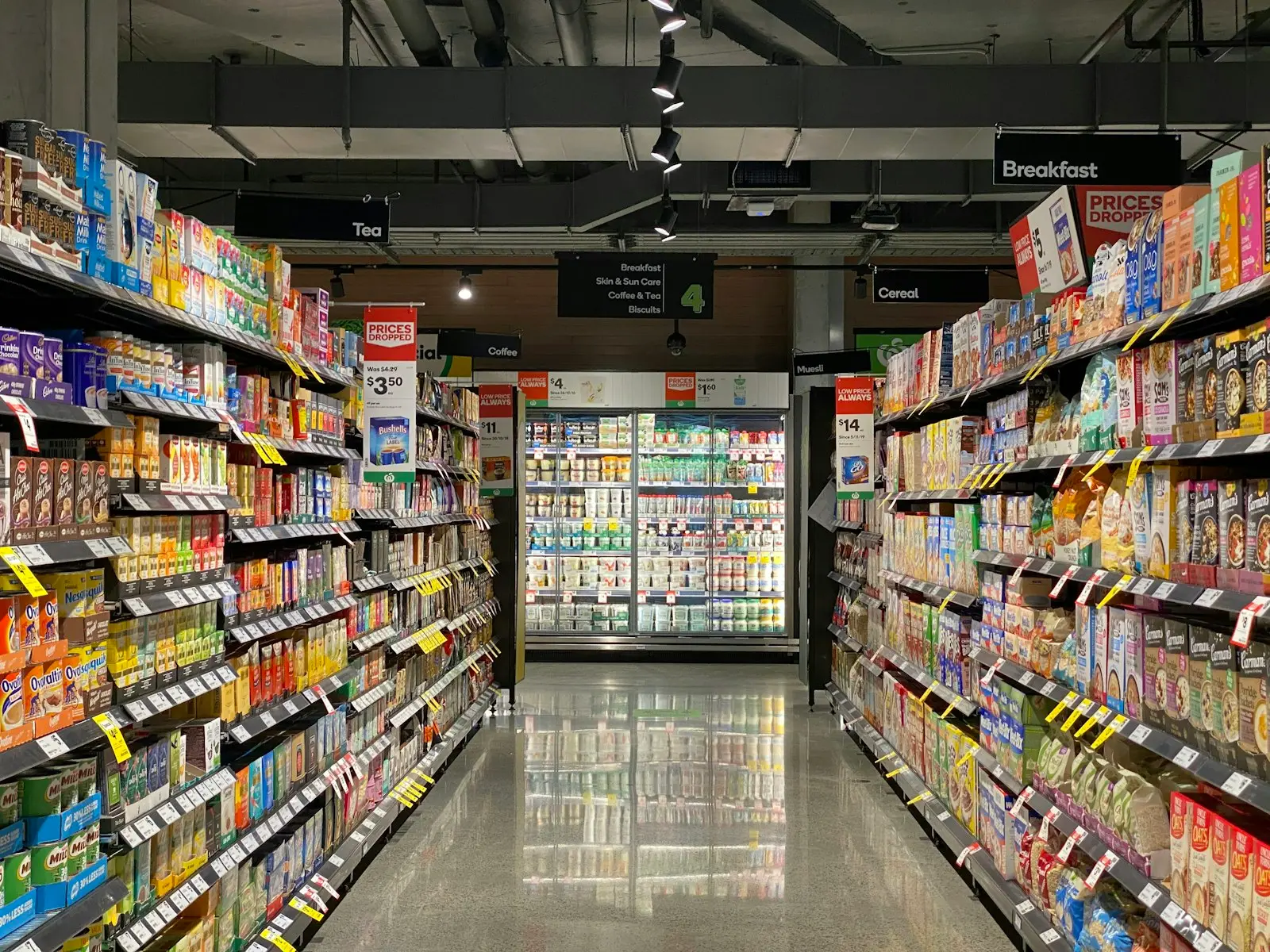 Pasillo de supermercado con refrigeradores al fondo